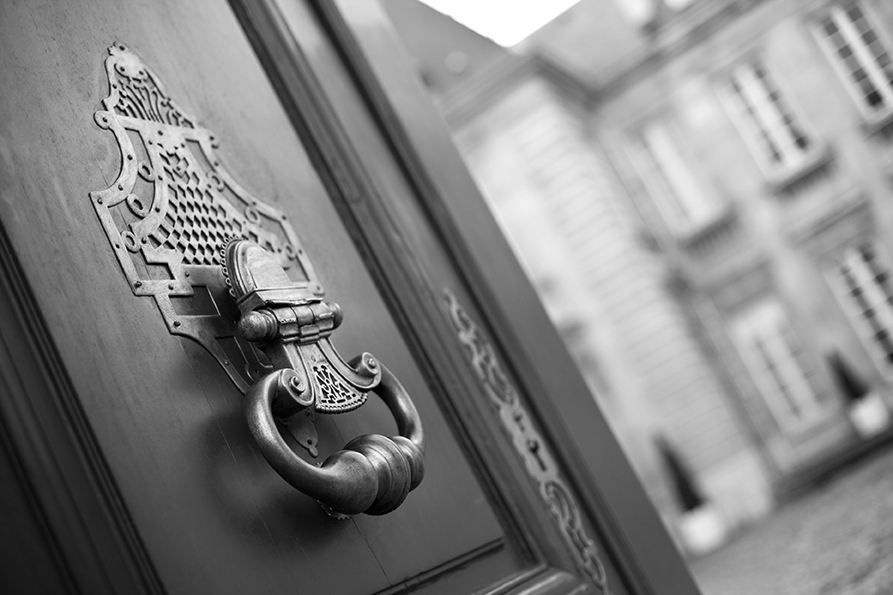 image représentant une porte en bois, avec un crochet doré, image en noir et blanc
